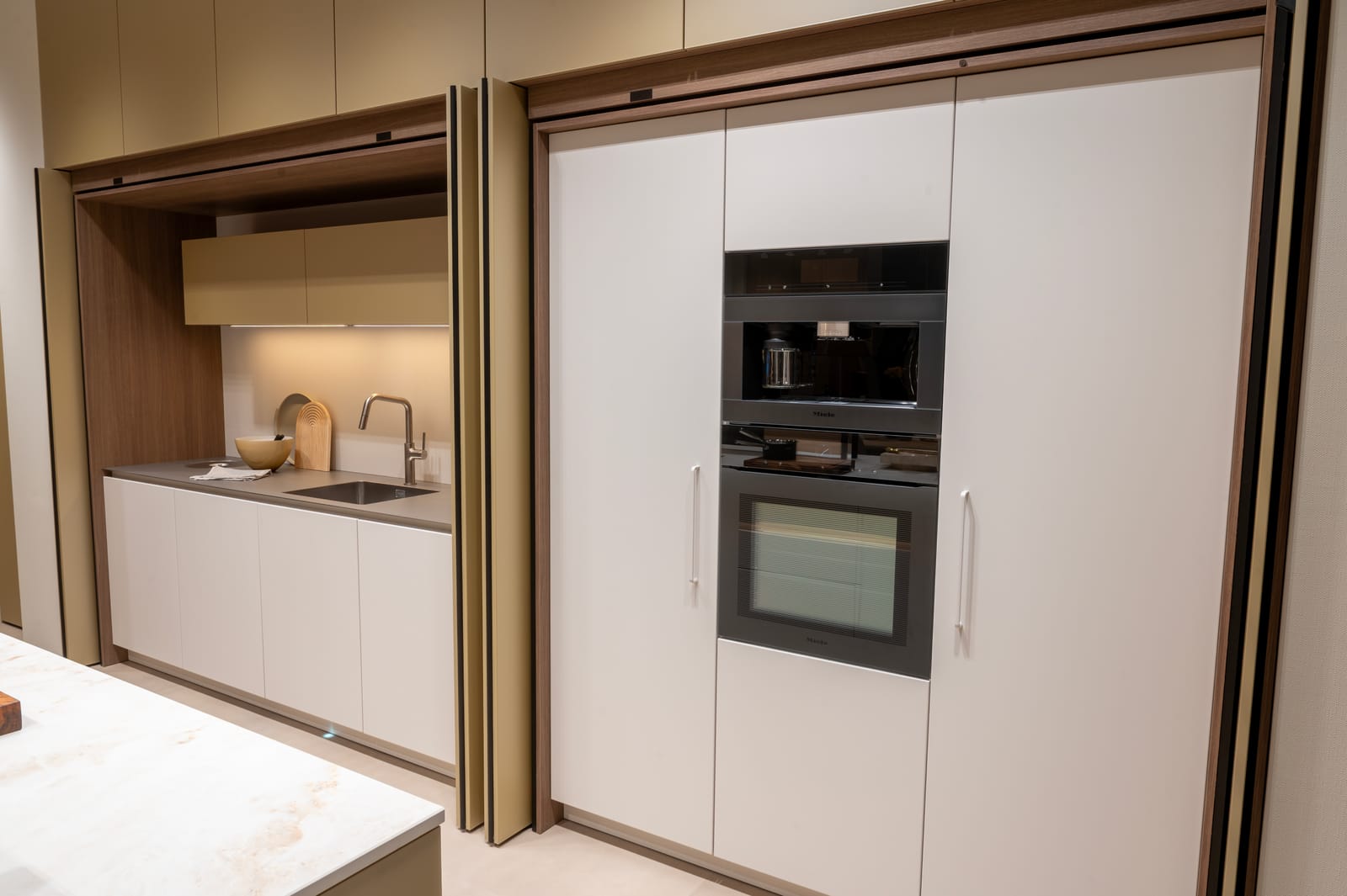 Keuken met pocketdeuren die een verborgen werkplek met spoelbak tonen